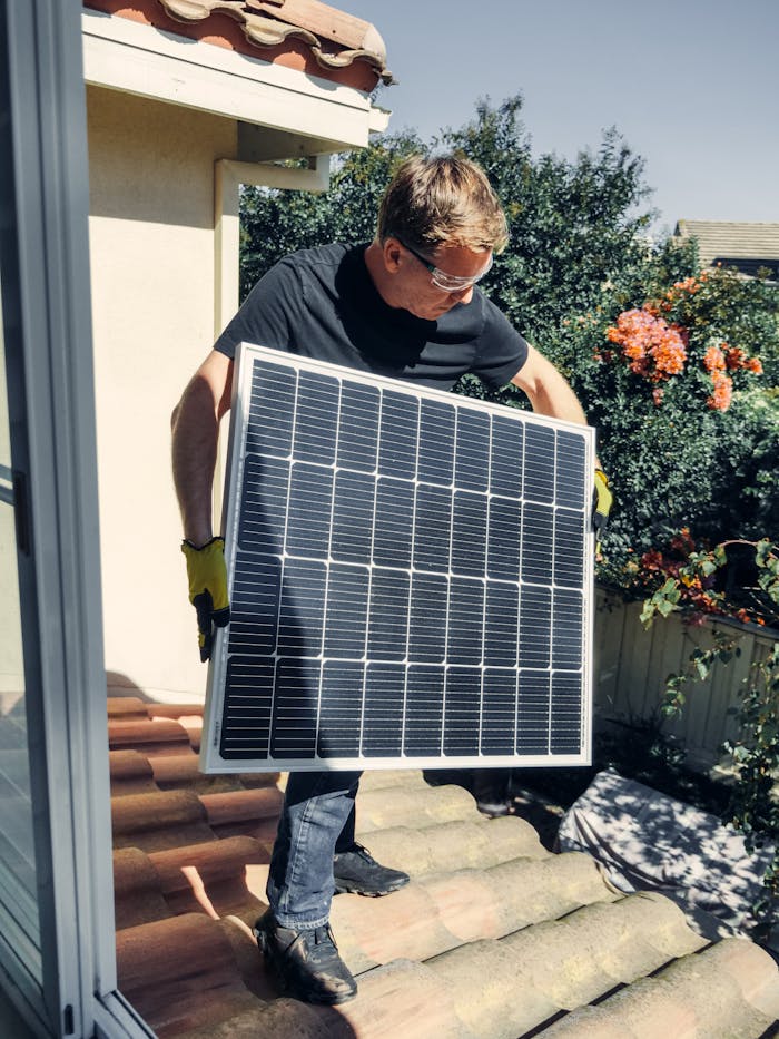 A worker installs a solar panel on a roof, promoting clean and renewable energy.